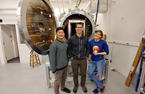 SPACE Lab's Sungyoung Ha, Curtis Promislow, and Anna Sheppard in front of the Space Test Facility.