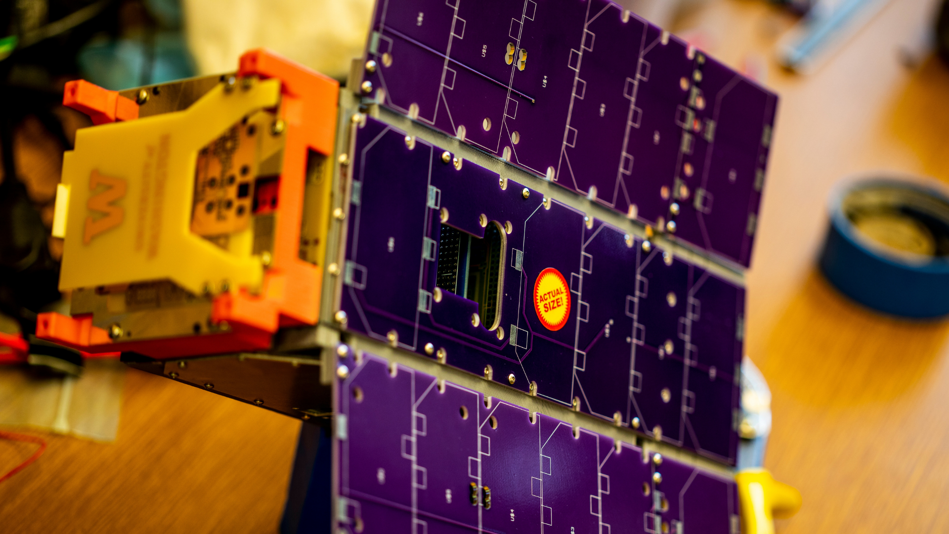 Small satellite device with solar panels on wings that unfold