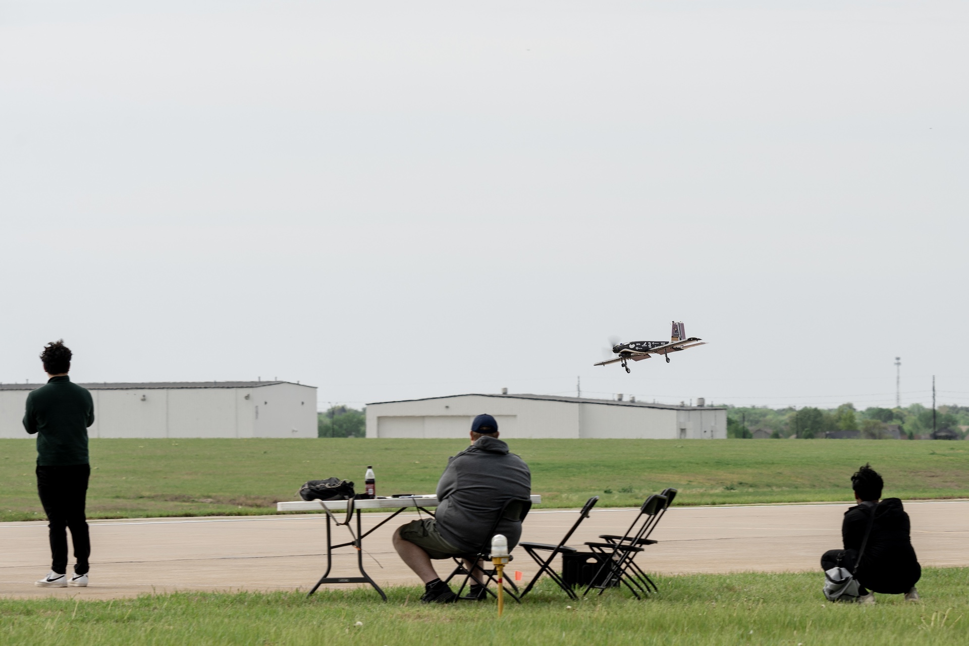 Three engineers watching a remote control aircraft in the air