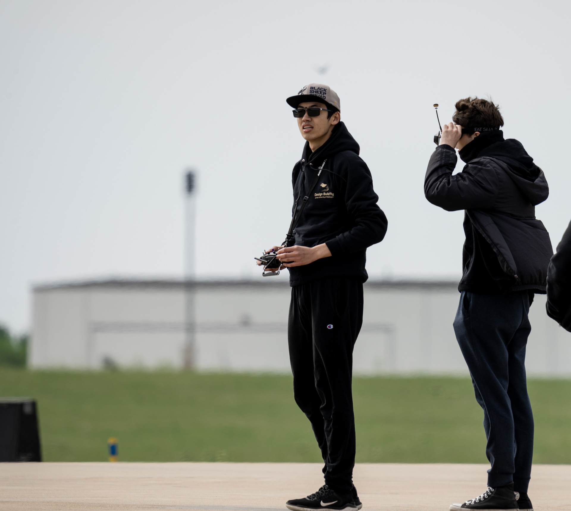 A person standing and operating an aircraft with a remote control